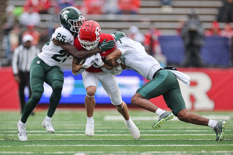 Oct 14, 2023; Piscataway, New Jersey, USA; Rutgers Scarlet Knights wide receiver Christian Dremel (6) is tackled by Michigan State Spartans defensive back Chance Rucker (25) and defensive back Jaden Mangham (1)  during the first half at SHI Stadium. Mandatory Credit: Vincent Carchietta-USA TODAY Sports