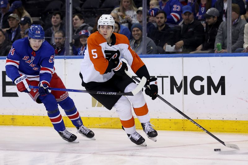 Mar 26, 2024; New York, New York, USA; Philadelphia Flyers defenseman Egor Zamula (5) controls the puck against New York Rangers right wing Kaapo Kakko (24) during the first period at Madison Square Garden. Mandatory Credit: Brad Penner-USA TODAY Sports