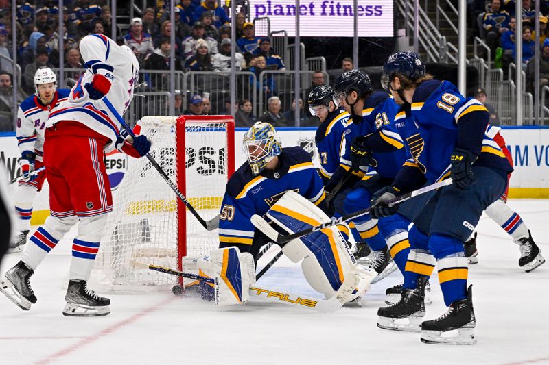 Jan 11, 2024; St. Louis, Missouri, USA;  St. Louis Blues goaltender Jordan Binnington (50) defends the net against New York Rangers left wing Alexis Lafreniere (13) during the third period at Enterprise Center. Mandatory Credit: Jeff Curry-USA TODAY Sports