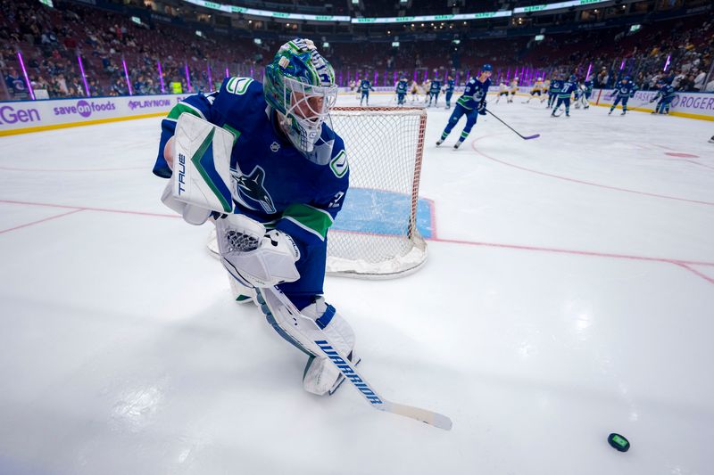 Nov 17, 2024; Vancouver, British Columbia, CAN; Vancouver Canucks goalie Kevin Lankinen (32) handles the puck during warm up prior to a game against the Nashville Predators at Rogers Arena. Mandatory Credit: Bob Frid-Imagn Images