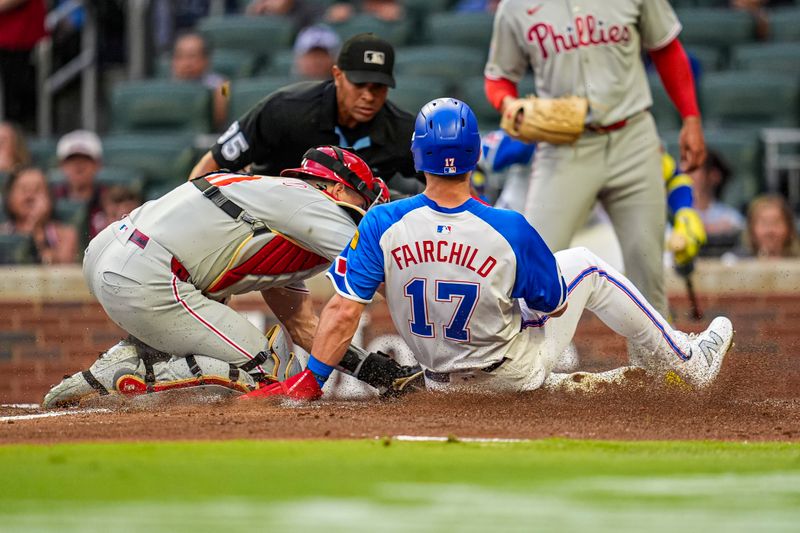 Jun 28, 2025; Cumberland, Georgia, USA; Philadelphia Phillies catcher J.T. Realmuto (10) tags out Atlanta Braves left fielder Stuart Fairchild (17) at home plate during the second inning at Truist Park. Mandatory Credit: Dale Zanine-Imagn Images