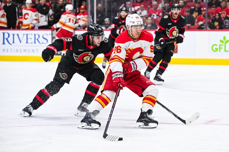 Nov 25, 2024; Ottawa, Ontario, CAN; Calgary Flames left wing Andrei Kuzmenko (96) plays the puck against Ottawa Senators right wing Drake Batherson (19) during the second period at Canadian Tire Centre. Mandatory Credit: David Kirouac-Imagn Images