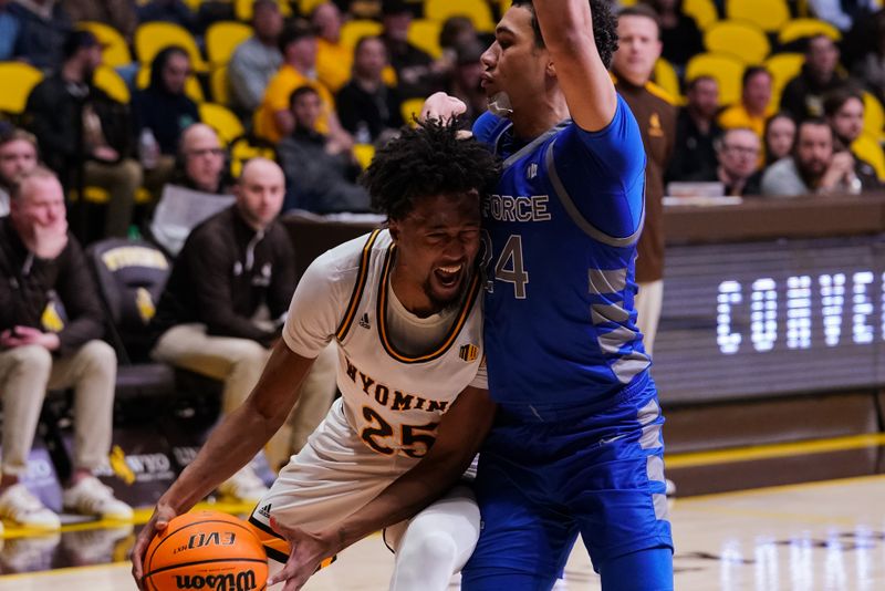 Feb 17, 2023; Laramie, Wyoming, USA; Wyoming Cowboys forward Jeremiah Oden (25) is defended by Air Force Falcons guard Jeffrey Mills (24) during the second half at Arena-Auditorium. Mandatory Credit: Troy Babbitt-USA TODAY Sports