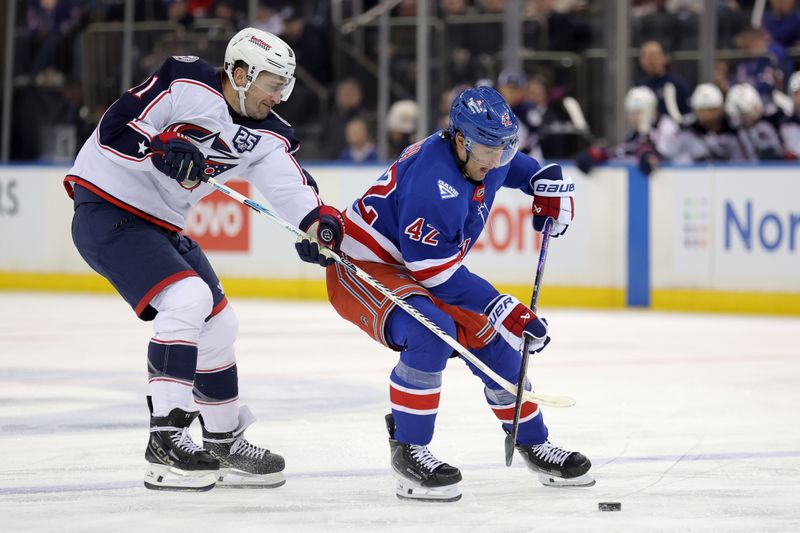 Mar 2, 2026; New York, New York, USA; Columbus Blue Jackets left wing Miles Wood (11) and New York Rangers center Noah Laba (42) fight for the puck during the second period at Madison Square Garden. Mandatory Credit: Brad Penner-Imagn Images
