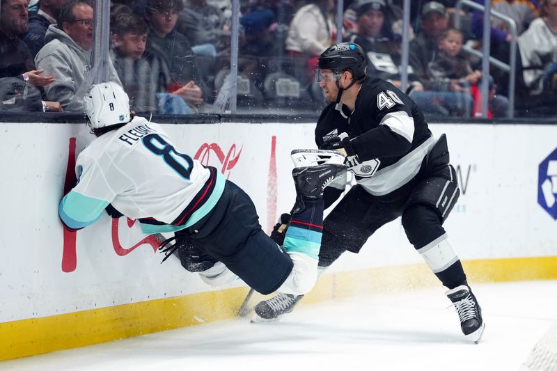 Dec 23, 2025; Los Angeles, California, USA; LA Kings right wing Joel Armia (40) checks Seattle Kraken defenseman Cale Fleury (8) into the boards in the second period at Crypto.com Arena. Mandatory Credit: Kirby Lee-Imagn Images