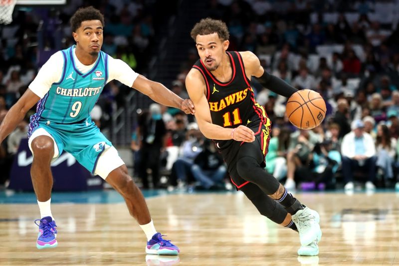 CHARLOTTE, NORTH CAROLINA - OCTOBER 25: Trae Young #11 of the Atlanta Hawks dribbles the ball to the basket while being defended by Theo Maledon #9 of the Charlotte Hornets during the first half of a basketball game at Spectrum Center on October 25, 2023 in Charlotte, North Carolina. NOTE TO USER: User expressly acknowledges and agrees that, by downloading and or using this photograph, User is consenting to the terms and conditions of the Getty Images License Agreement. (Photo by David Jensen/Getty Images)