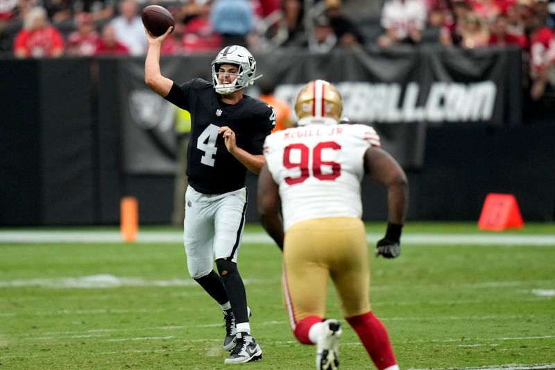 Las Vegas Raiders quarterback Aidan O'Connell (4) throws as San Francisco 49ers defensive tackle T.Y. McGill (96) pursues during the first half of an NFL preseason football game, Sunday, Aug. 13, 2023, in Las Vegas. (AP Photo/John Locher)