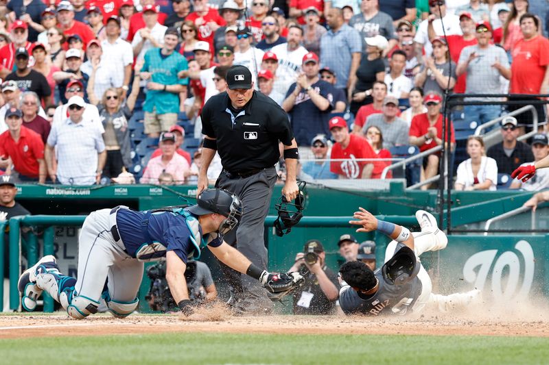 May 25, 2024; Washington, District of Columbia, USA; Washington Nationals catcher Keibert Ruiz (20) scores a run ahead of a tag by Seattle Mariners catcher Cal Raleigh (29) during the seventh inning at Nationals Park. Mandatory Credit: Geoff Burke-USA TODAY Sports