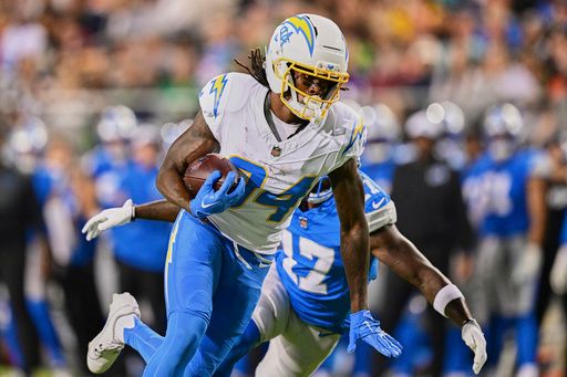 Los Angeles Chargers wide receiver KeAndre Lambert-Smith catches a pass and runs into the end zone in front of Detroit Lions Dicaprio Bootle (17) for a touchdown in the first half of the Pro Football Hall of Fame NFL preseason game Thursday, July 31, 2025, in Canton, Ohio. (AP Photo/David Dermer)