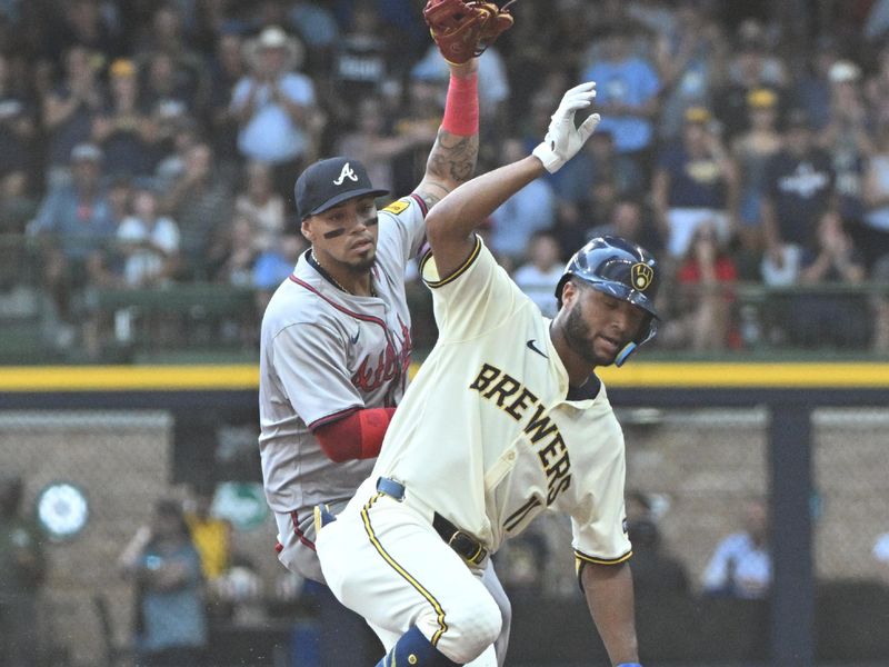 Jul 31, 2024; Milwaukee, Wisconsin, USA; Milwaukee Brewers outfielder Jackson Chourio (11) stretches a hit into a double against Atlanta Braves shortstop Orlando Arcia (11) in the second inning at American Family Field. Mandatory Credit: Michael McLoone-USA TODAY Sports