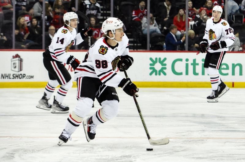 Dec 14, 2024; Newark, New Jersey, USA; Chicago Blackhawks center Connor Bedard (98) skates with the puck against the New Jersey Devils during the third period at Prudential Center. Mandatory Credit: John Jones-Imagn Images