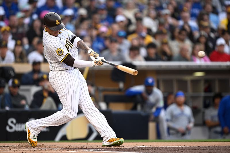 Apr 20, 2024; San Diego, California, USA; San Diego Padres designated hitter Manny Machado (13) hits a single against the Toronto Blue Jays during the first inning at Petco Park. Mandatory Credit: Orlando Ramirez-USA TODAY Sports