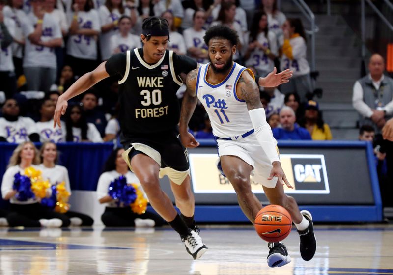 Jan 25, 2023; Pittsburgh, Pennsylvania, USA; Pittsburgh Panthers guard Jamarius Burton (11) dribbles up court as Wake Forest Demon Deacons guard Damari Monsanto (30) chases during the first half at the Petersen Events Center. Mandatory Credit: Charles LeClaire-USA TODAY Sports