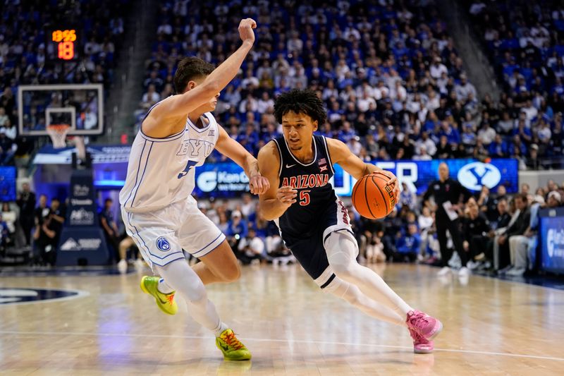 Jan 26, 2026; Provo, Utah, USA; Arizona Wildcats guard Brayden Burries (5) drives to the basket while being defended by BYU Cougars forward Mihailo Bošković (5) at Marriott Center. Mandatory Credit: Aaron Baker-Imagn Images 