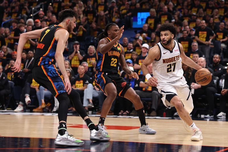 OKLAHOMA CITY, OKLAHOMA - MAY 05: Jamal Murray #27 of the Denver Nuggets is defended by Cason Wallace #22 and Chet Holmgren #7 of the Oklahoma City Thunder during the third quarter of Round Two Game One of the 2025 NBA Playoffs at Paycom Center on May 05, 2025 in Oklahoma City, Oklahoma. NOTE TO USER: User expressly acknowledges and agrees that, by downloading and or using this photograph, user is consenting to the terms and conditions of the Getty Images License Agreement. (Photo by Sam Hodde/Getty Images)