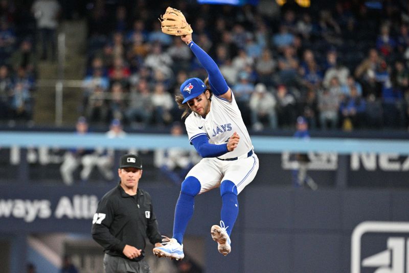 Apr 8, 2024; Toronto, Ontario, CAN;  Toronto Blue Jays shortstop Bo Bichette (11) leaps to catch a throw from the outfield after a double by Seattle Mariners left fielder Dominic Canzone (not shown) in the ninth inning at Rogers Centre. Mandatory Credit: Dan Hamilton-USA TODAY Sports