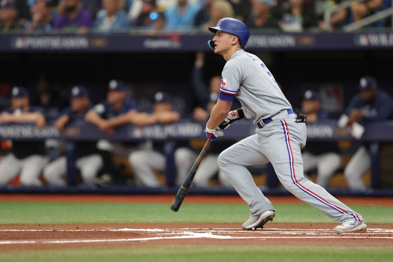 Oct 4, 2023; St. Petersburg, Florida, USA; Texas Rangers shortstop Corey Seager (5) hits a double against the Tampa Bay Rays in the first inning during game two of the Wildcard series for the 2023 MLB playoffs at Tropicana Field. Mandatory Credit: Nathan Ray Seebeck-USA TODAY Sports