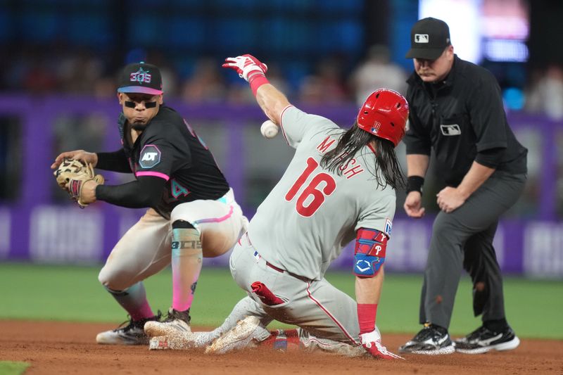 Sep 6, 2025; Miami, Florida, USA;  Philadelphia Phillies left fielder Brandon Marsh (16) slides into second base with a double in the eighth inning as Miami Marlins second baseman Maximo Acosta (24) looks on at loanDepot Park. Mandatory Credit: Jim Rassol-Imagn Images