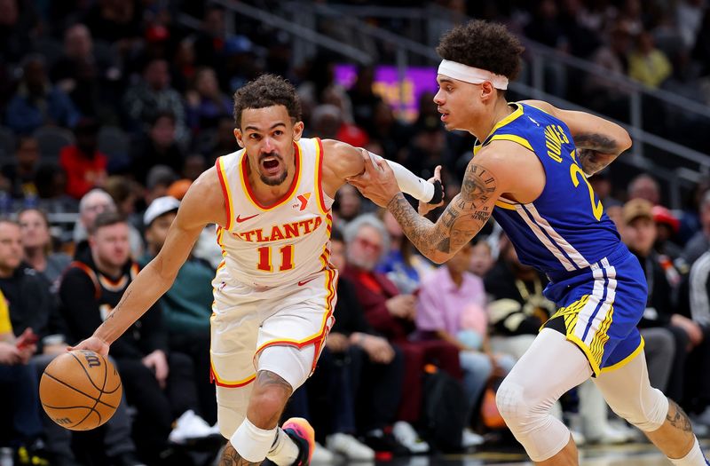 ATLANTA, GEORGIA - FEBRUARY 03:  Trae Young #11 of the Atlanta Hawks drives against Lester Quinones #25 of the Golden State Warriors during the second quarter at State Farm Arena on February 03, 2024 in Atlanta, Georgia.  NOTE TO USER: User expressly acknowledges and agrees that, by downloading and/or using this photograph, user is consenting to the terms and conditions of the Getty Images License Agreement.  (Photo by Kevin C. Cox/Getty Images)