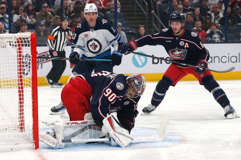 Nov 1, 2024; Columbus, Ohio, USA; Columbus Blue Jackets goalie Elvis Merzlikins (90) makes a save as Winnipeg Jets center Gabriel Vilardi (13) looks for a rebound during the first period at Nationwide Arena. Mandatory Credit: Russell LaBounty-Imagn Images