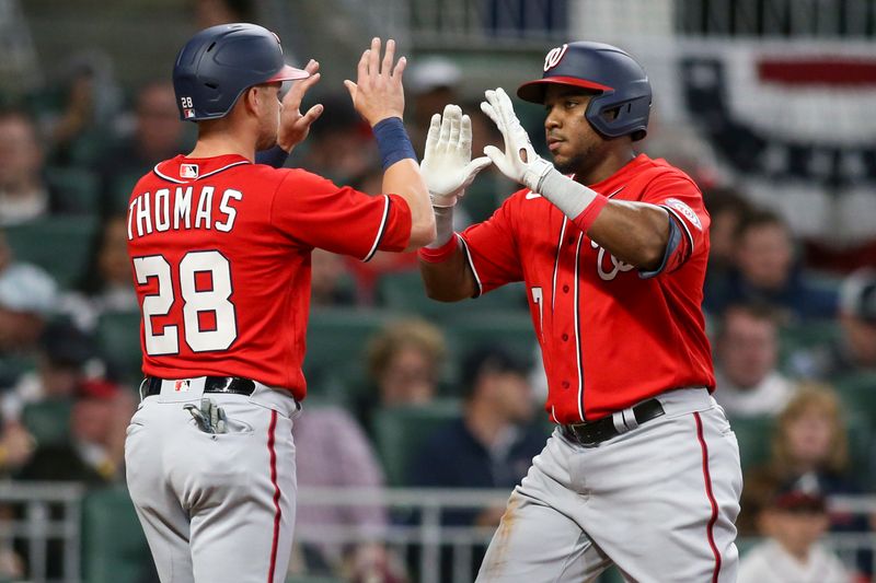 Apr 11, 2022; Atlanta, Georgia, USA; Washington Nationals third baseman Maikel Franco (right) celebrates with left fielder Lane Thomas (28) after hitting a two-run home run against the Atlanta Braves in the third inning at Truist Park. Mandatory Credit: Brett Davis-USA TODAY Sports