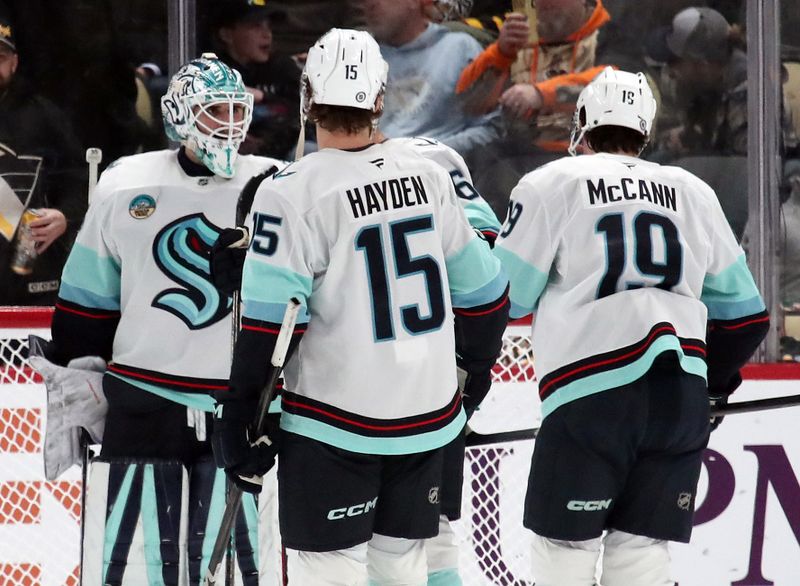 Jan 14, 2025; Pittsburgh, Pennsylvania, USA;  Seattle Kraken goaltender Joey Daccord (35) and center John Hayden (15) and left wing Jared McCann (19) celebrate after defeating the Pittsburgh Penguins at PPG Paints Arena. Mandatory Credit: Charles LeClaire-Imagn Images