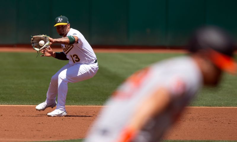 Aug 20, 2023; Oakland, California, USA; Oakland Athletics third baseman Jordan Diaz (13) fields a grounder by Baltimore Orioles third baseman Ram  n Ur  as during the first inning at Oakland-Alameda County Coliseum. Mandatory Credit: D. Ross Cameron-USA TODAY Sports