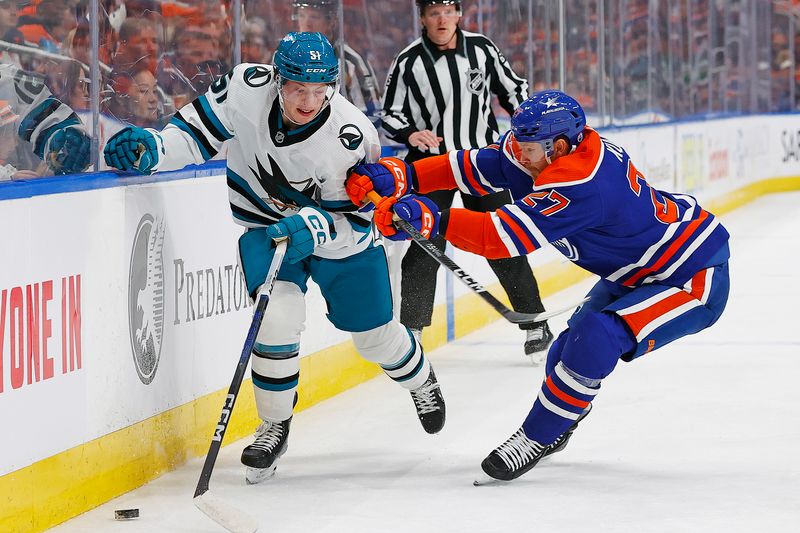 Apr 15, 2024; Edmonton, Alberta, CAN; Edmonton Oilers defensemen Brett Kulak (27) and San Jose Sharks forward Collin Graf (51) battle along the boards for a loose puck  during the second period at Rogers Place. Mandatory Credit: Perry Nelson-USA TODAY Sports