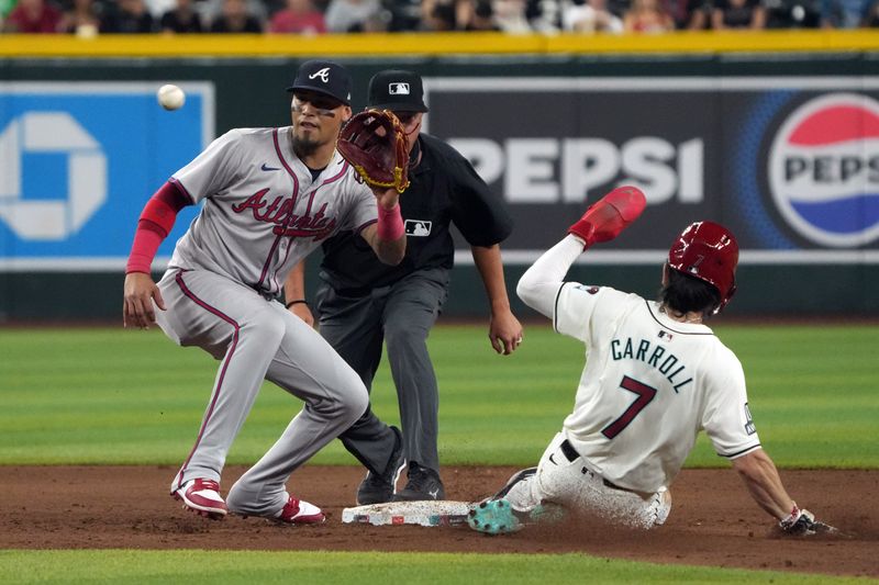 Jul 8, 2024; Phoenix, Arizona, USA; Arizona Diamondbacks outfielder Corbin Carroll (7) steals the base under the tag by Atlanta Braves shortstop Orlando Arcia (11) in the sixth inning at Chase Field. Mandatory Credit: Rick Scuteri-USA TODAY Sports