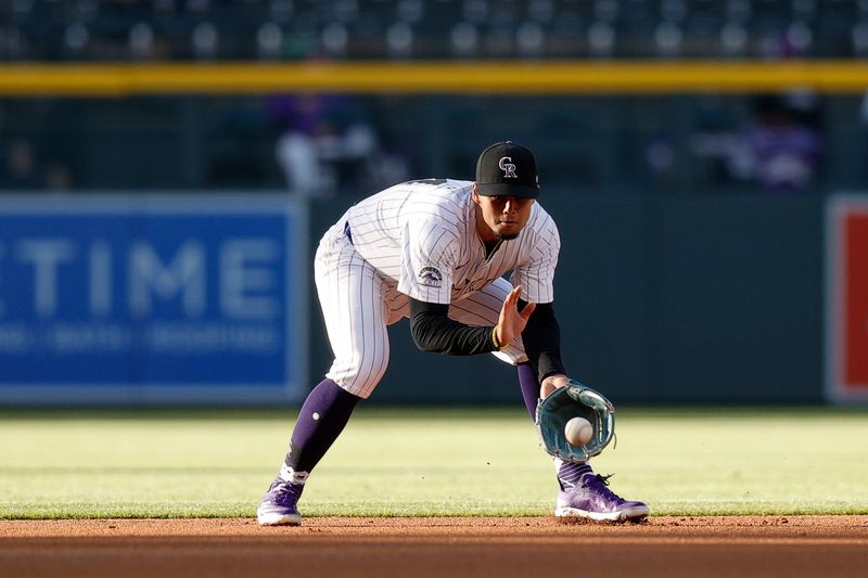 May 7, 2024; Denver, Colorado, USA; Colorado Rockies shortstop Ezequiel Tovar (14) fields the ball in the first inning against the San Francisco Giants at Coors Field. Mandatory Credit: Isaiah J. Downing-USA TODAY Sports