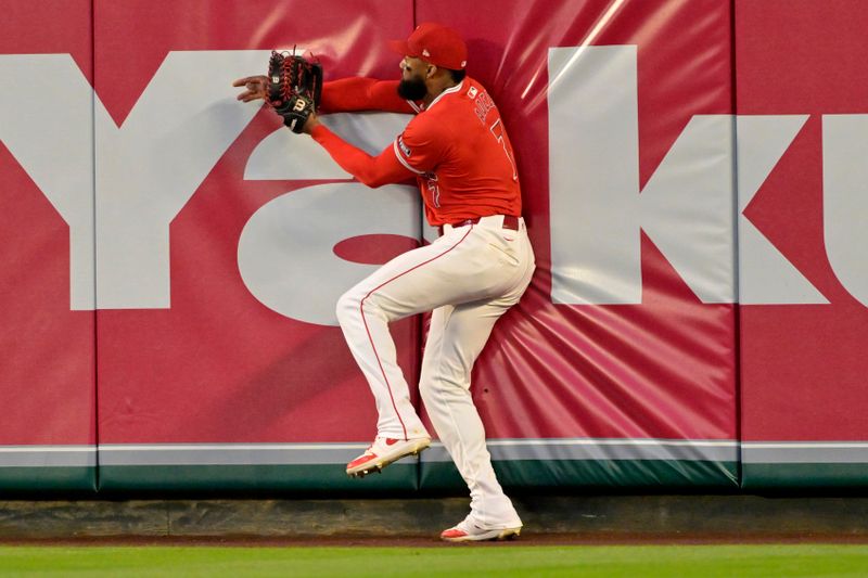 Apr 29, 2024; Anaheim, California, USA; Los Angeles Angels outfielder Jo Adell (7) crashes into the wall after a leaping catch off a ball hit by Philadelphia Phillies outfielder Nick Castellanos (not pictured) in the fourth inning at Angel Stadium. Mandatory Credit: Jayne Kamin-Oncea-USA TODAY Sports