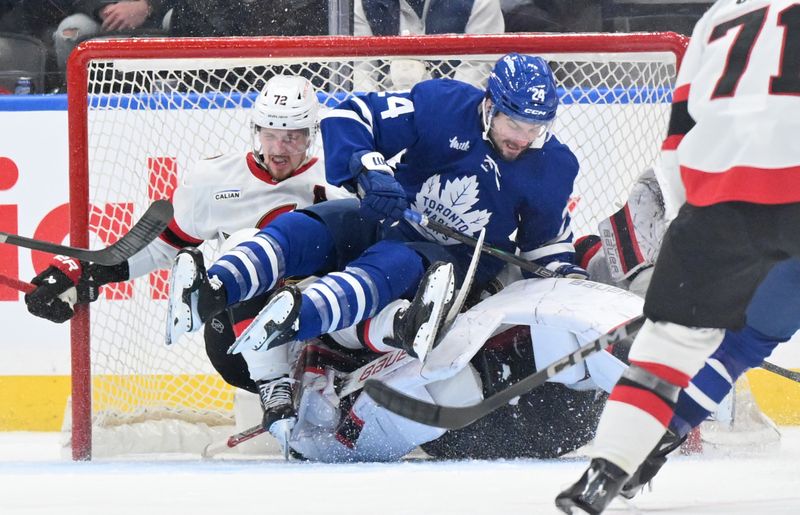 Mar 15, 2025; Toronto, Ontario, CAN;  Toronto Maple Leafs forward Scott Laughton (24) lands on top of Ottawa Senators goalie Linus Ullmark (35) after colliding with defenseman Thomas Chabot (72) in the second period at Scotiabank Arena. Mandatory Credit: Dan Hamilton-Imagn Images
