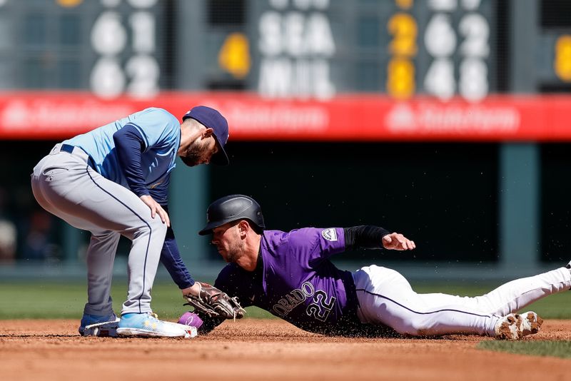 Apr 7, 2024; Denver, Colorado, USA; Colorado Rockies left fielder Nolan Jones (22) is tagged out attempting to steal second against Tampa Bay Rays second baseman Brandon Lowe (8) in the second inning at Coors Field. Mandatory Credit: Isaiah J. Downing-USA TODAY Sports