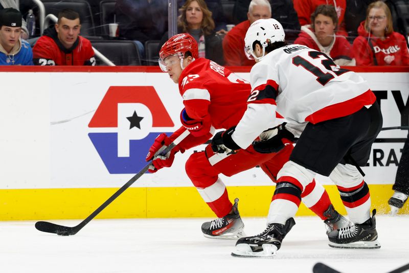 Jan 7, 2025; Detroit, Michigan, USA; Detroit Red Wings left wing Lucas Raymond (23) skates with the puck defended by Ottawa Senators center Shane Pinto (12) in the second period at Little Caesars Arena. Mandatory Credit: Rick Osentoski-Imagn Images