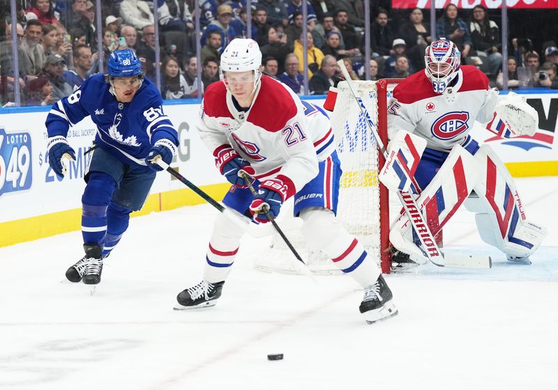 Nov 9, 2024; Toronto, Ontario, CAN; Toronto Maple Leafs right wing William Nylander (88) battles for the puck with Montreal Canadiens defenseman Kaiden Guhle (21) during the first period at Scotiabank Arena. Mandatory Credit: Nick Turchiaro-Imagn Images