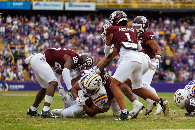 Nov 25, 2023; Baton Rouge, Louisiana, USA;  LSU Tigers running back Noah Cain (21) is tackled by Texas A&M Aggies defensive back Demani Richardson (26) during the second half at Tiger Stadium. Mandatory Credit: Stephen Lew-USA TODAY Sports