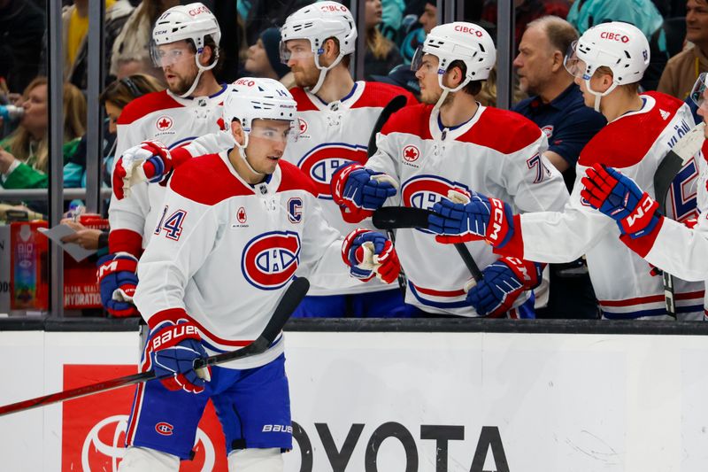 Mar 24, 2024; Seattle, Washington, USA; Montreal Canadiens center Nick Suzuki (14) high-fives teammates on the bench after scoring a goal against the Seattle Kraken during the first period at Climate Pledge Arena. Mandatory Credit: Joe Nicholson-USA TODAY Sports