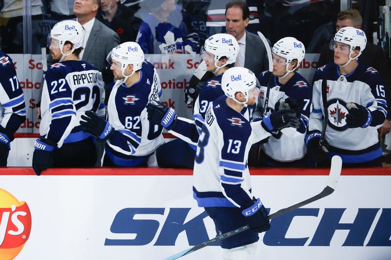 Oct 28, 2024; Winnipeg, Manitoba, CAN;  Winnipeg Jets forward Gabriel Vilardi (13) is congratulated by his teammates on his goal against the Toronto Maple Leafs during the third period at Canada Life Centre. Mandatory Credit: Terrence Lee-Imagn Images