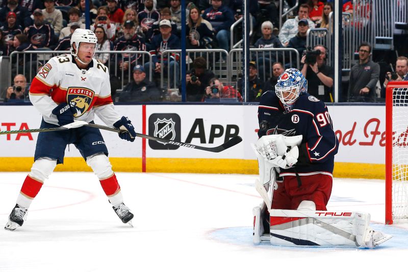 Oct 15, 2024; Columbus, Ohio, USA; Columbus Blue Jackets goalie Elvis Merzlikins (90) makes a save as Florida Panthers center Carter Verhaeghe (23) looks for a rebound during the third period at Nationwide Arena. Mandatory Credit: Russell LaBounty-Imagn Images