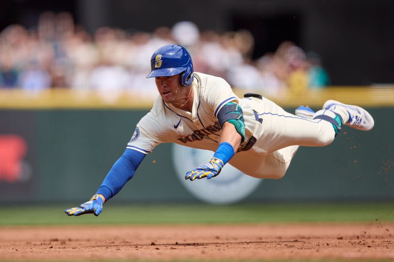 Jul 21, 2024; Seattle, Washington, USA; Seattle Mariners left fielder Dylan Moore (25) dives into third base for a triple against the Houston Astros during the second inning at T-Mobile Park. Mandatory Credit: John Froschauer-USA TODAY Sports