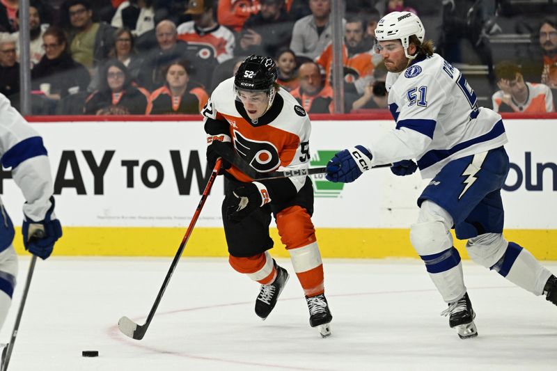 Jan 10, 2026; Philadelphia, Pennsylvania, USA; Philadelphia Flyers center Denver Barkey (52) and Tampa Bay Lightning defenseman Charle-Edouard D'Astous (51) battle for the puck during the first period at Xfinity Mobile Arena. Mandatory Credit: Eric Hartline-Imagn Images