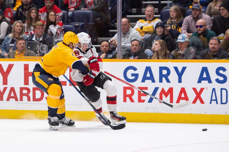 Feb 13, 2024; Nashville, Tennessee, USA;  Nashville Predators defenseman Luke Schenn (2) and New Jersey Devils center Jack Hughes (86) fight for the puck during the second period at Bridgestone Arena. Mandatory Credit: Steve Roberts-USA TODAY Sports