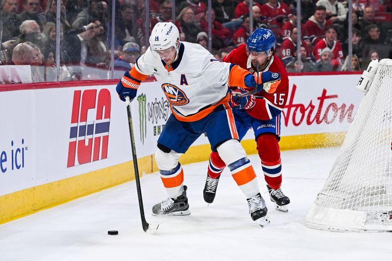 Feb 26, 2026; Montreal, Quebec, CAN; New York Islanders center Bo Horvat (14) plays the puck against Montreal Canadiens center Alex Newhook (15) during the third period at Bell Centre. Mandatory Credit: David Kirouac-Imagn Images