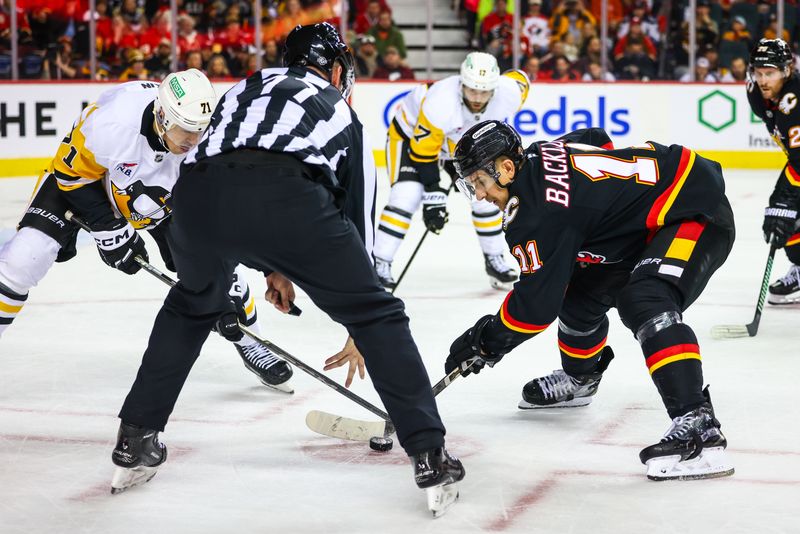 Oct 22, 2024; Calgary, Alberta, CAN; Calgary Flames center Mikael Backlund (11) and Pittsburgh Penguins center Evgeni Malkin (71) face off for the puck during the overtime period at Scotiabank Saddledome. Mandatory Credit: Sergei Belski-Imagn Images