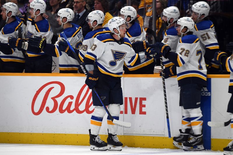 Apr 4, 2024; Nashville, Tennessee, USA; St. Louis Blues left wing Jake Neighbours (63) celebrates with teammates after a goal during the third period against the Nashville Predators at Bridgestone Arena. Mandatory Credit: Christopher Hanewinckel-USA TODAY Sports