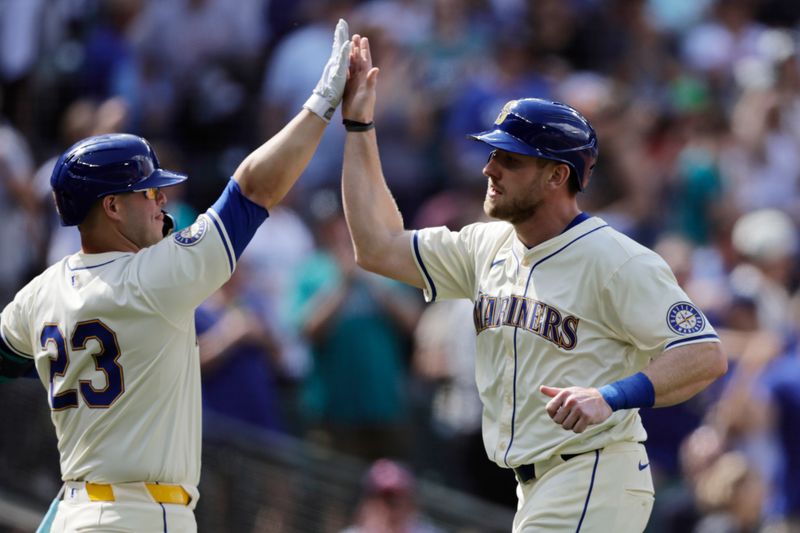 Jun 30, 2024; Seattle, Washington, USA; Seattle Mariners right fielder Luke Raley (20) is congratulated by Seattle Mariners first baseman Ty France (23) after scoring during the seventh inning against the Minnesota Twins at T-Mobile Park. Mandatory Credit: John Froschauer-USA TODAY Sports