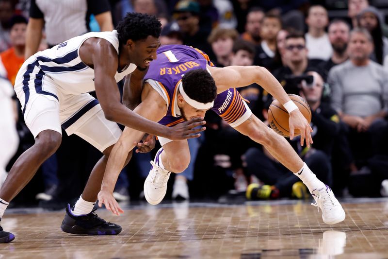 PHOENIX, ARIZONA - JANUARY 07: Vince Williams Jr. #5 of the Memphis Grizzlies and Devin Booker #1 of the Phoenix Suns battle for control of a loose ball during the first half at Footprint Center on January 07, 2024 in Phoenix, Arizona. NOTE TO USER: User expressly acknowledges and agrees that, by downloading and or using this photograph, User is consenting to the terms and conditions of the Getty Images License Agreement.  (Photo by Chris Coduto/Getty Images)