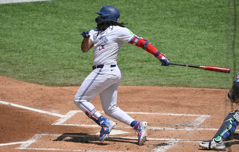 Jun 16, 2024; Toronto, Ontario, CAN;  Toronto Blue Jays first baseman Vladimir Guerrero Jr. (27) hits a single against the Cleveland Guardians in the first inning at Rogers Centre. Mandatory Credit: Dan Hamilton-USA TODAY Sports