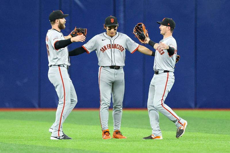 Apr 13, 2024; St. Petersburg, Florida, USA;  San Francisco Giants center fielder Jung Hoo Lee (51) outfielder Austin Slater (13) and right fielder Mike Yastrzemski (5) celebrate after beating the Tampa Bay Rays at Tropicana Field. Mandatory Credit: Nathan Ray Seebeck-USA TODAY Sports