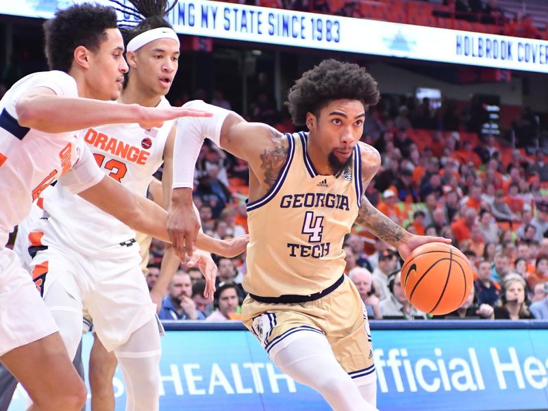 Feb 28, 2023; Syracuse, New York, USA; Georgia Tech Yellow Jackets forward Javon Franklin (4) drives the ball past Syracuse Orange center Jesse Edwards (14) and forward Benny Williams (13) in the first half at the JMA Wireless Dome. Mandatory Credit: Mark Konezny-USA TODAY Sports